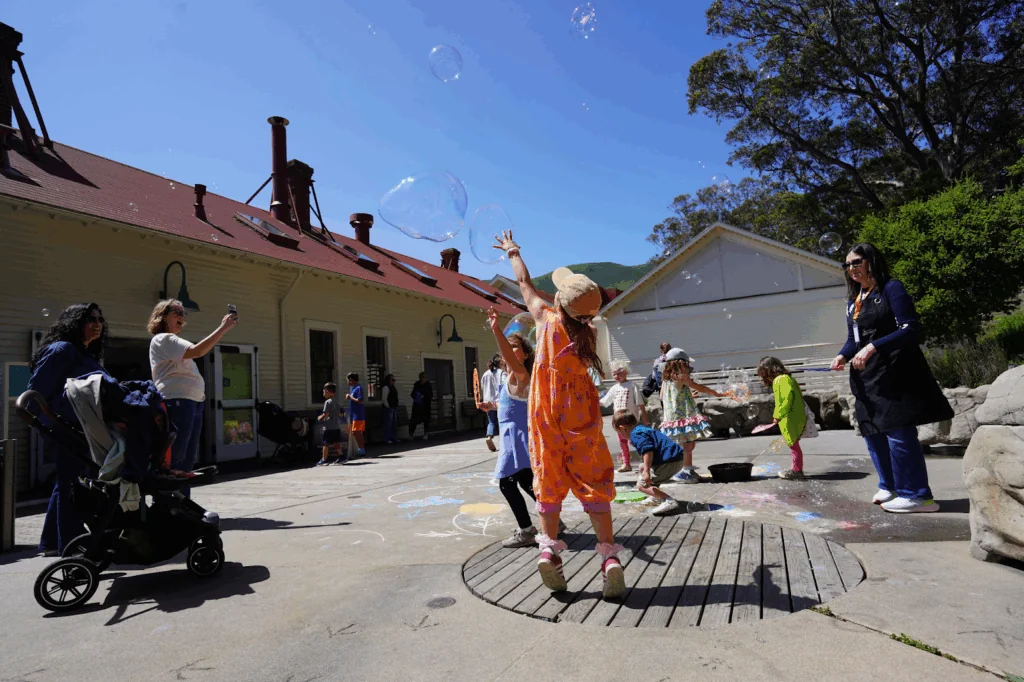 Young children playing with bubbles and chalk outside, one of the best Bay Area activities