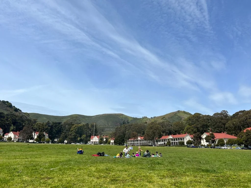 A group of people enjoying a picnic at the Fort Baker parade ground, one of the best free things to do in San Francisco