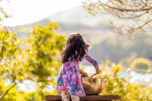 A young girl playing with mud in the Mud Kitchen at Bay Area Discovery Museum