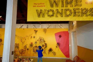 A young boy displays his artwork on a gallery wall at a children’s creativity museum