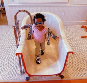 A toddler stands in half a bathtub, a unique exhibit at the Bay Area Discovery Museum