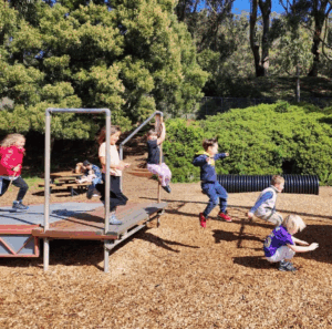 Multiple kids play outside on a playground at the Bay Area Discovery Museum