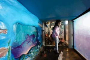 A young girl explores the sea caves of Bay Hall at the Bay Area Discovery Museum