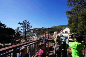 Children using a telescope on the Lookout Deck at the Bay Area Discovery Museum
