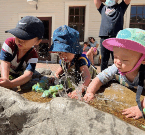 Three toddlers splashing water making for perfect Bay Area Discovery Museum photos