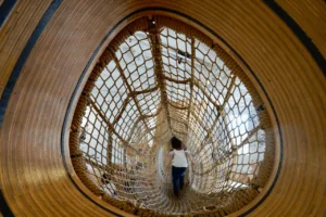 A child explores a woven tunnel at the Bay Area Discovery Museum, a children’s interactive museum